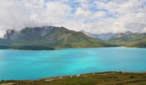 Scenic view of lake by mountains against sky