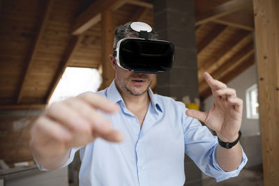 Man holding camera while standing at home