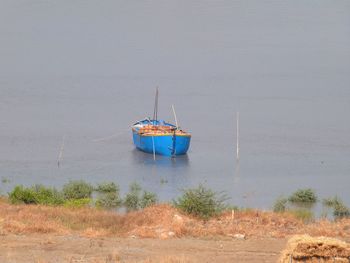 Sailboat moored on sea against sky