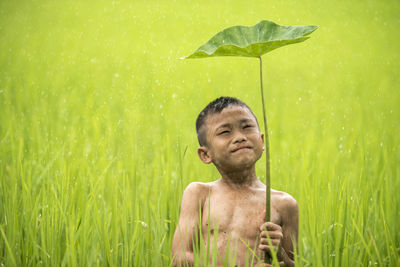 Boy standing on wet grass