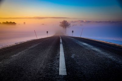 Road against sky in foggy weather during sunset