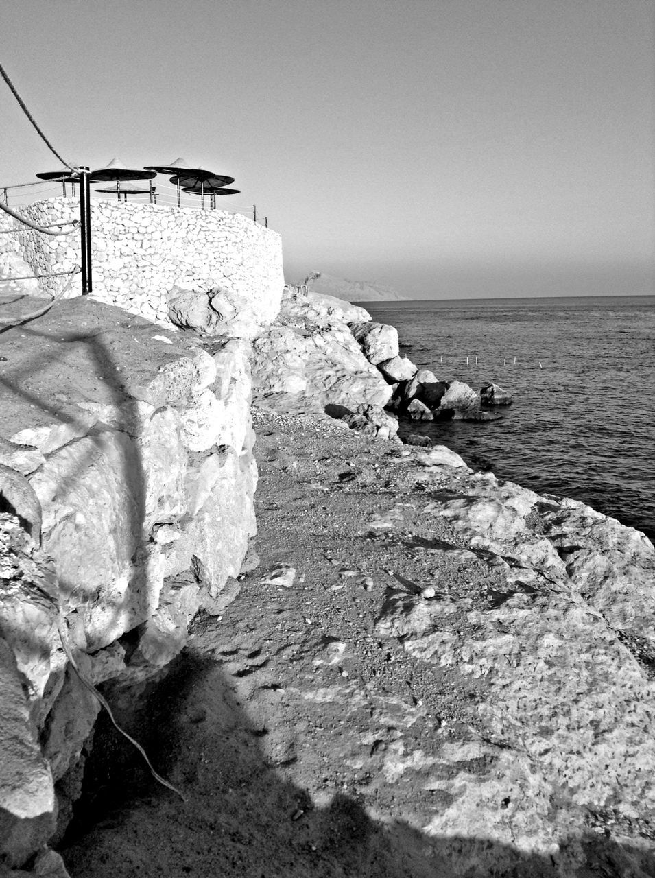sea, horizon over water, water, rock - object, clear sky, tranquil scene, tranquility, nature, scenics, beach, shore, rock, beauty in nature, sky, rock formation, copy space, built structure, outdoors, day, no people