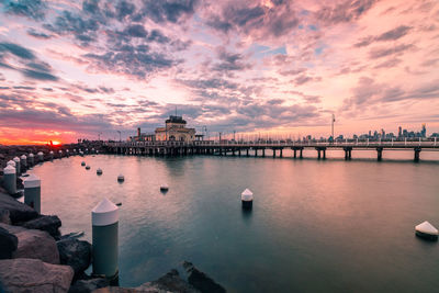 Scenic view of sea by city buildings against sky