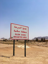 Information sign board on desert against sky