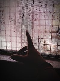 Close-up of hand on glass window