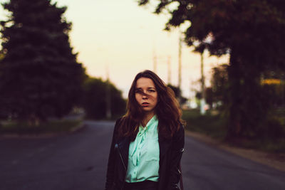 Portrait of young woman standing on road