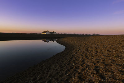 Scenic view of lake against clear sky during sunset