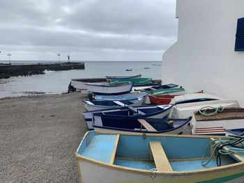 Boats moored on beach against sky