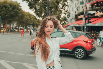 Thoughtful young woman standing on street in city