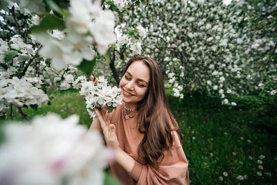 Beautiful young girl in the garden of blooming apple trees