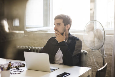 Businessman listening while sitting in conference room during business meeting