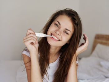 Portrait of smiling young woman lying on bed