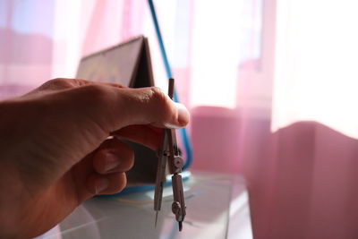 Cropped hand of person holding drawing compass