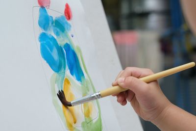 Close-up of hand holding multi colored pencils