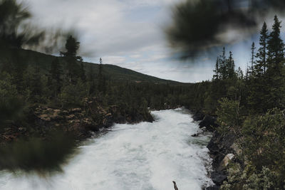 Scenic view of waterfall against sky