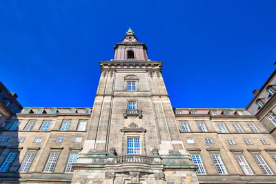 Low angle view of clock tower against clear blue sky