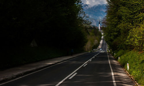 Road amidst trees against sky at night