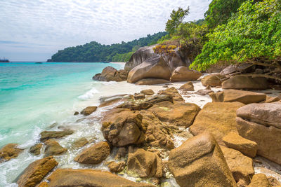 Rocks on beach against sky