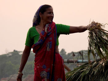 Side view of woman standing against sky