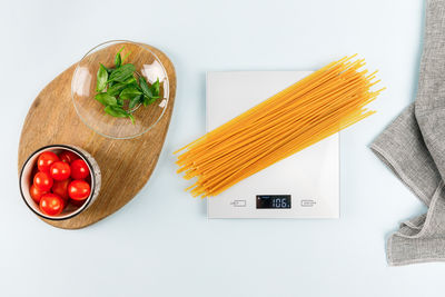 Dry spaghetti on grey digital kitchen scales. flat lay. kitchen equipment. pasta, italian cuisine.