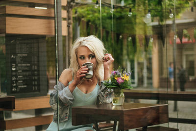 Portrait of a beautiful young woman wearing sunglasses at restaurant