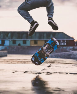 Low section of man skateboarding on beach