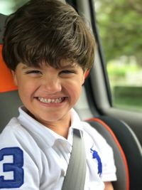 Portrait of boy smiling while sitting in car