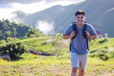 Portrait of smiling young man standing on field