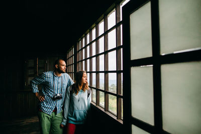 Couple looking through window while standing at observation point