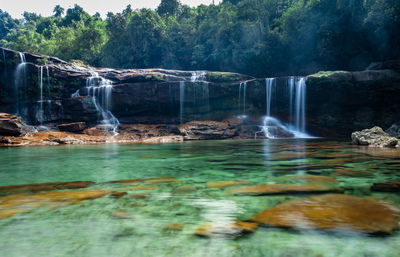 Natural waterfall white water streams with calm clear water at morning