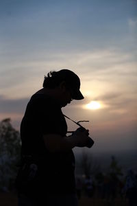 Silhouette man standing against sky during sunset