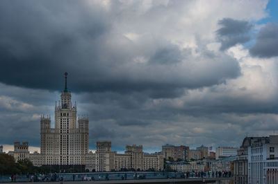 Buildings in city against cloudy sky