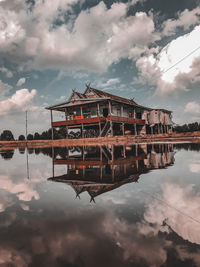 Reflection of building in lake against sky