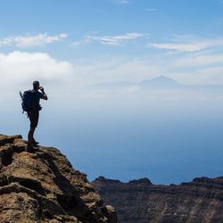 Woman standing on rock at seaside