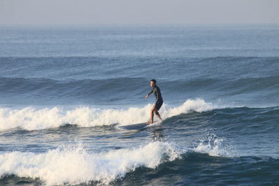 Man in sea against sky