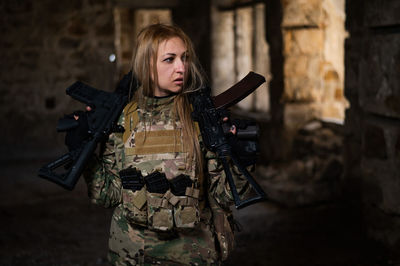 Portrait of young woman standing against wall