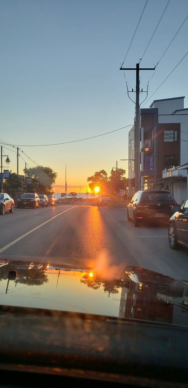 CARS ON ROAD AGAINST SKY DURING SUNSET