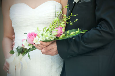 Midsection of woman holding flower bouquet