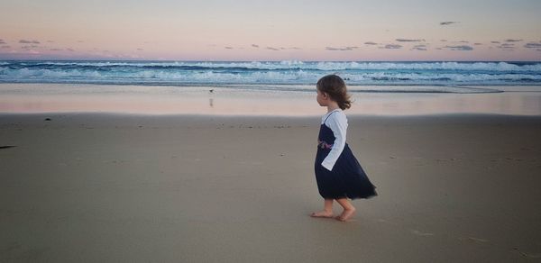 Full length of girl walking on shore at beach