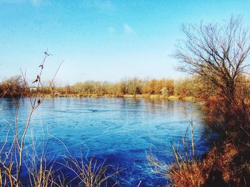 Scenic view of lake against clear blue sky