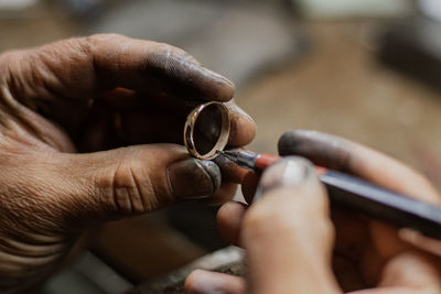 Cropped hands holding pen and ring