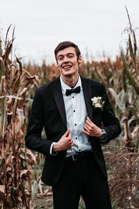 Portrait of smiling bridegroom standing on land