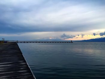 Pier on sea against cloudy sky