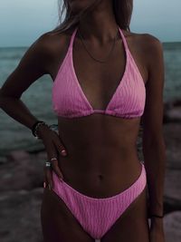 Midsection of woman standing at beach