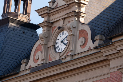 Low angle view of clock tower amidst buildings in city