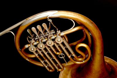 Close-up of french horn against black background