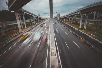 Blurred motion of vehicles on multiple lane highway below bridge