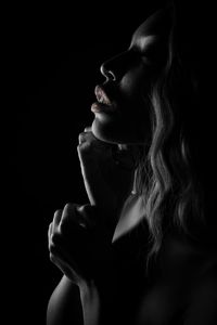 Close-up of sensuous woman against black background