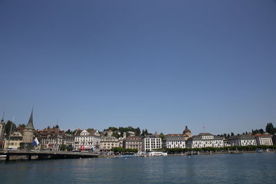 River in town against clear blue sky