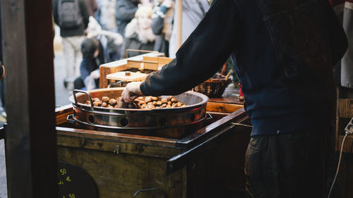 Midsection of man preparing food at market stall